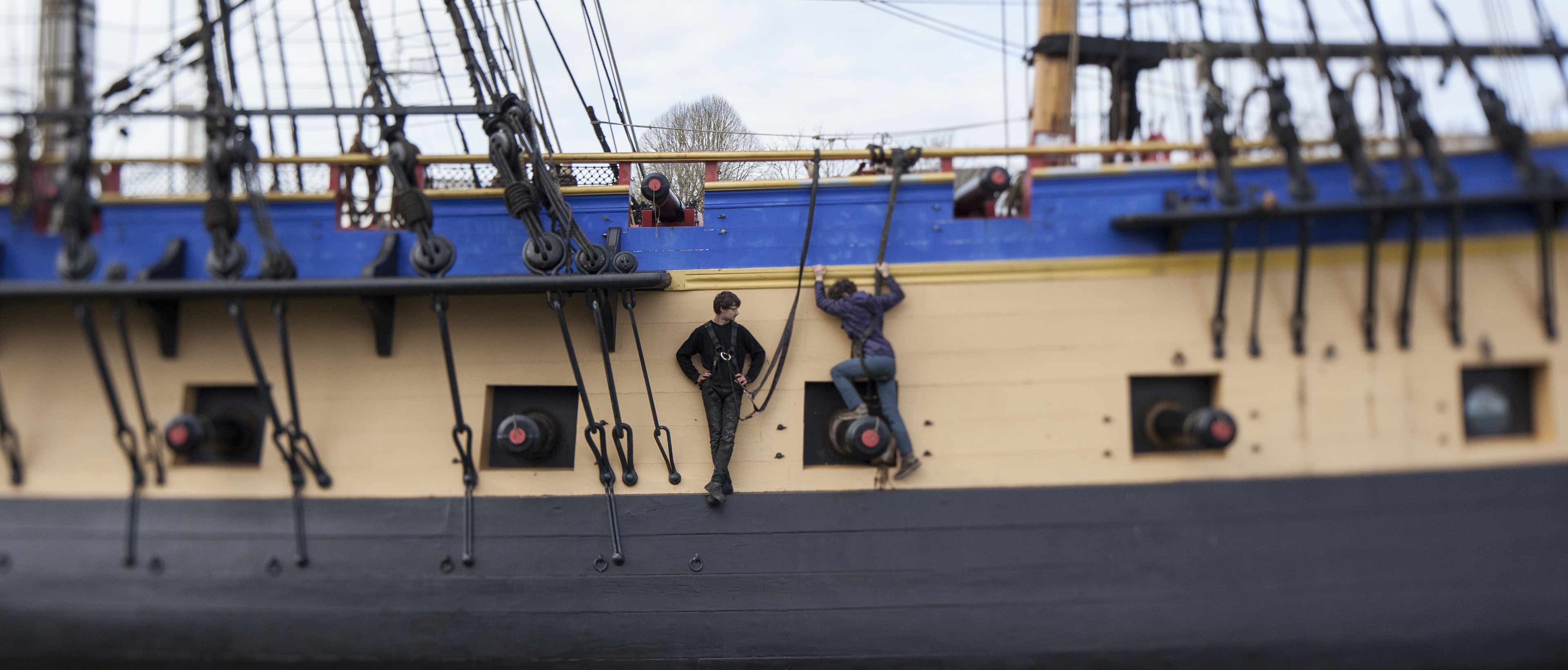 Jeunes hommes sur la coque du bateau l'Hermione 
