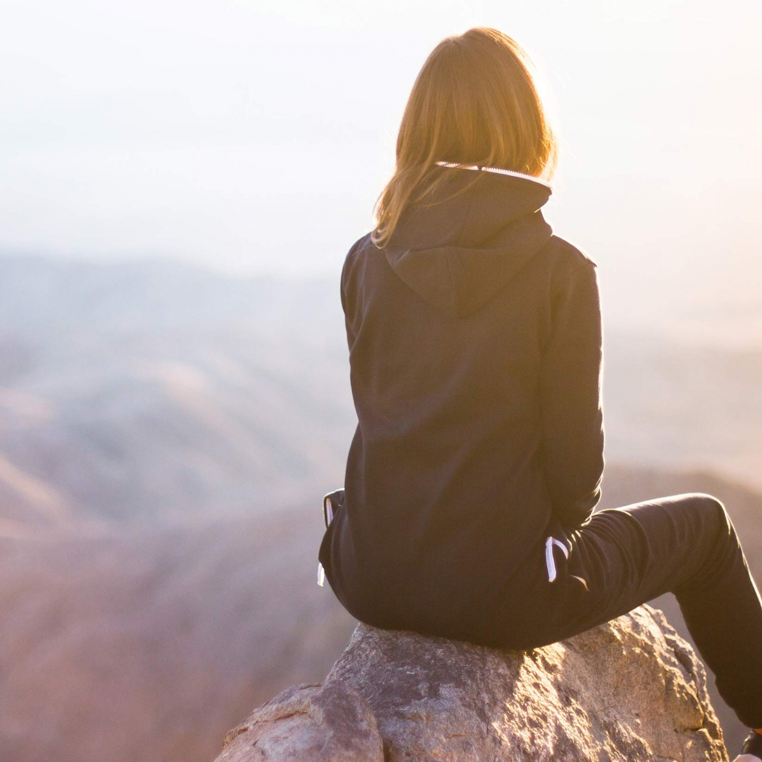 jeune femme au sommet d'une montagne