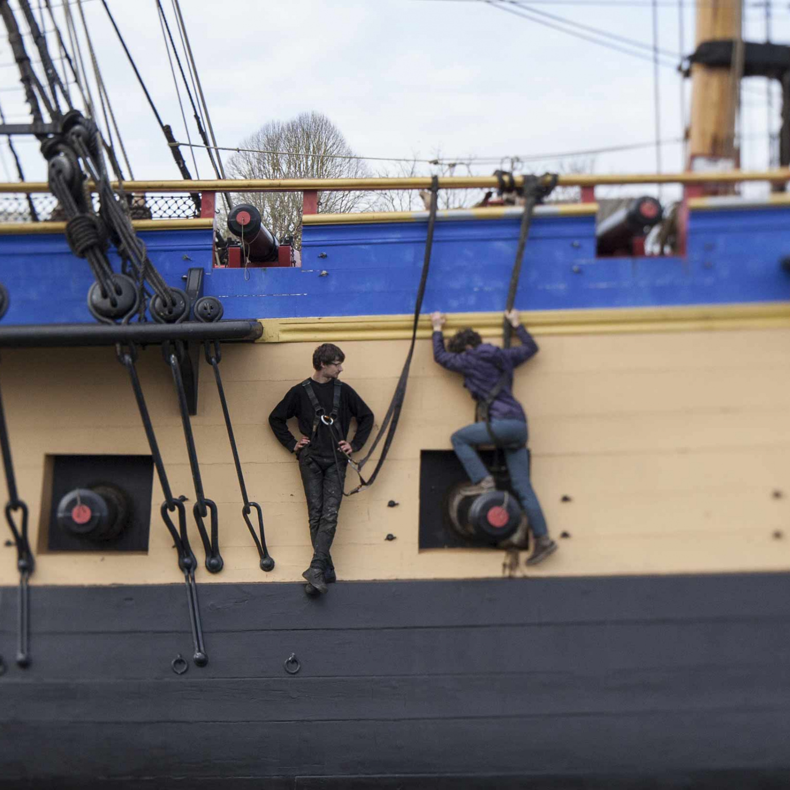 Jeunes hommes sur la coque du bateau l'Hermione 