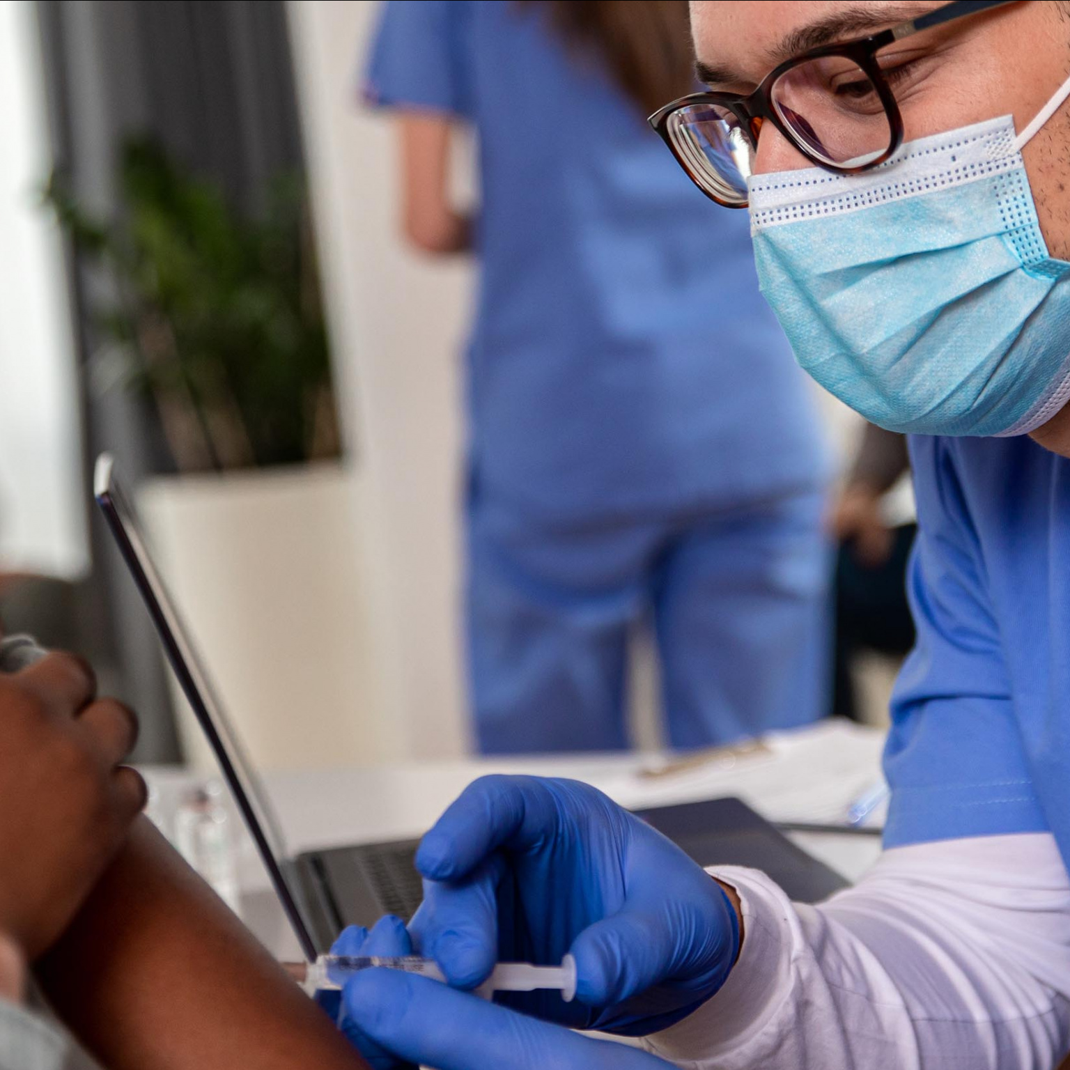 Infirmier masqué vaccinant une patiente