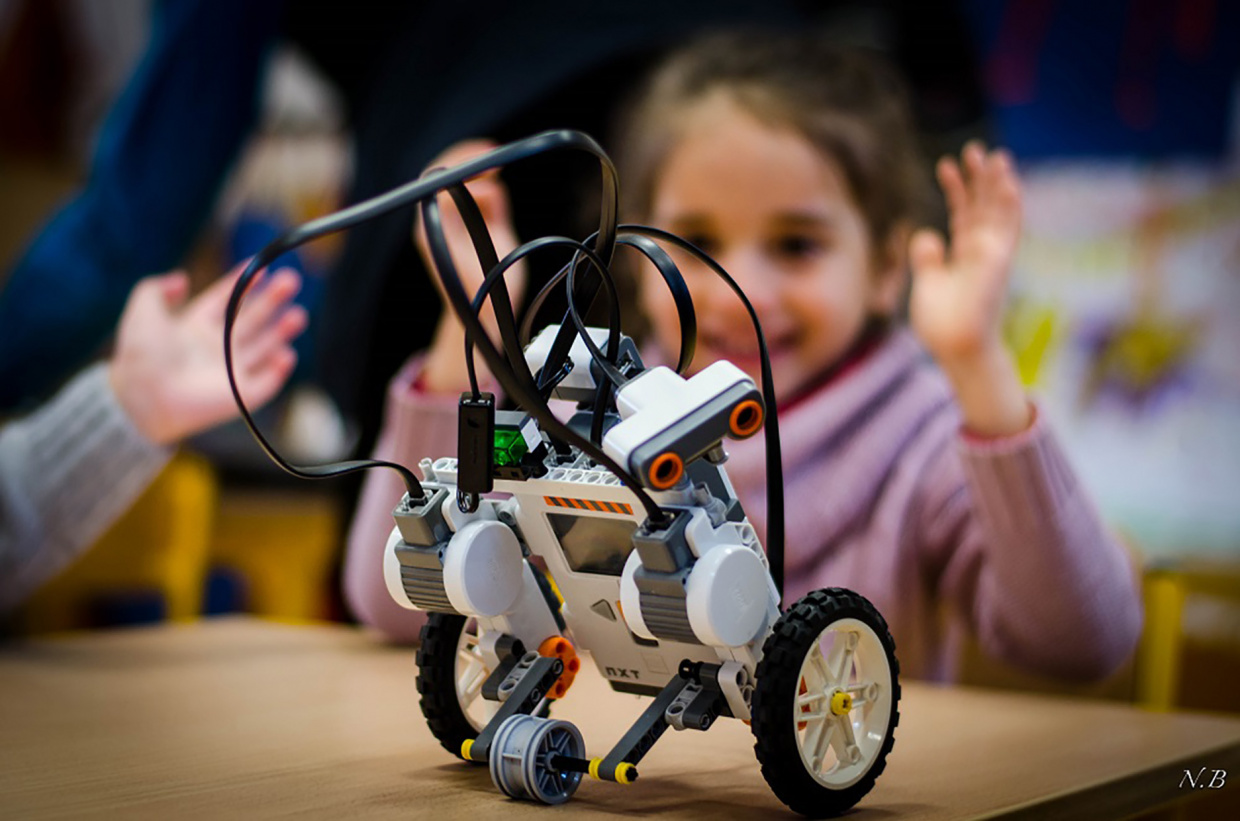 robocup junior - une fillette regarde un petit robot