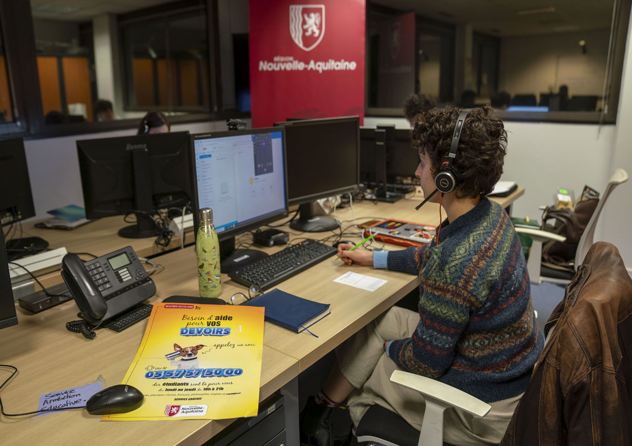 Bureau aide aux devoirs - un étudiant répond à un élève depuis son bureau